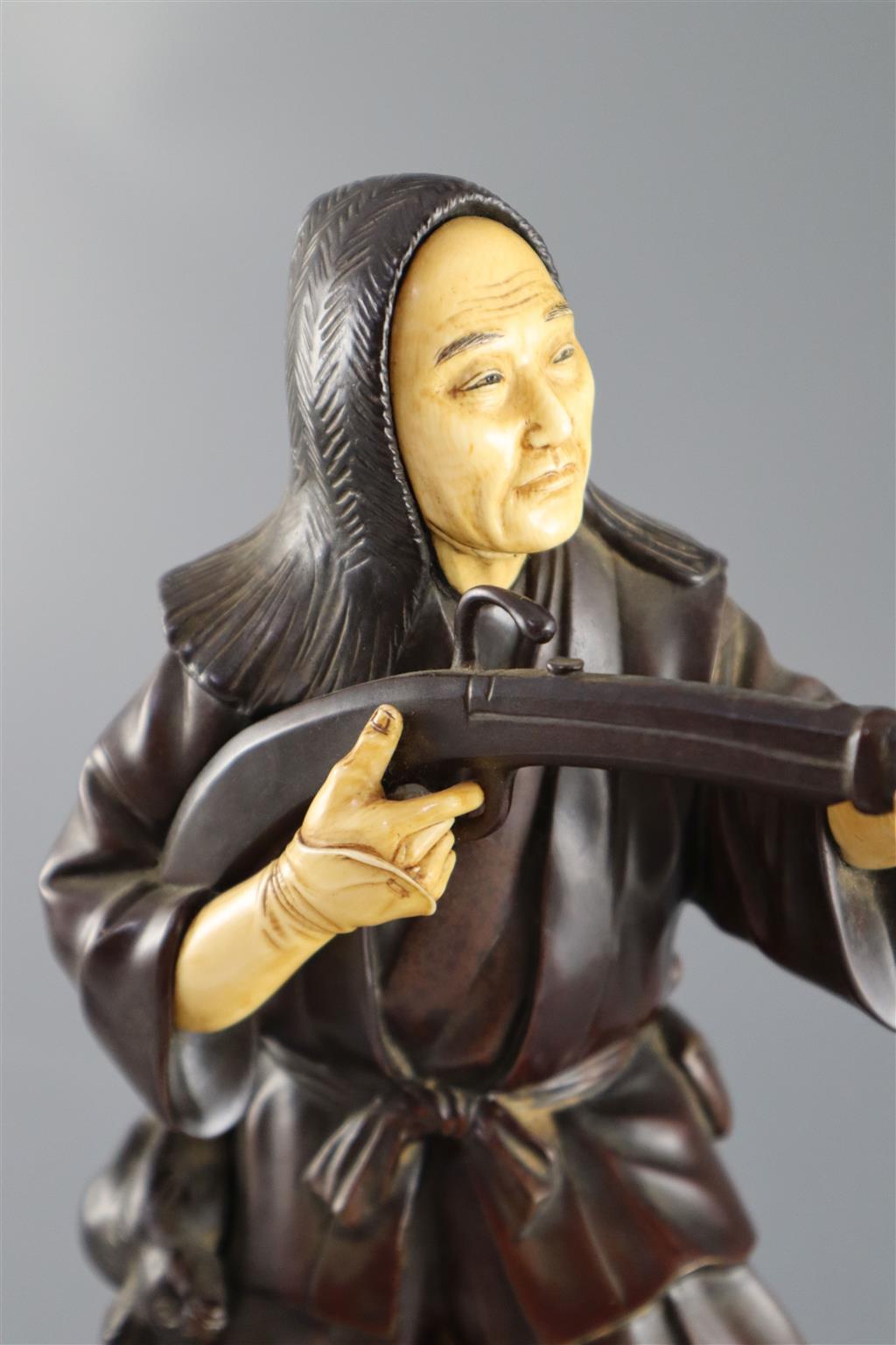 A good Japanese bronze and ivory okimono of a huntsman, Meiji period, 34cm high